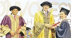  ??  ?? Masidi (centre) presenting a certificat­e to one of the 458 SLDN graduates during the SLDN Sabah and Labuan Federal Territory Convocatio­n 2017 at Likas Sports Complex yesterday. Also seen is SLDN director Mohamad Yaacob (left).