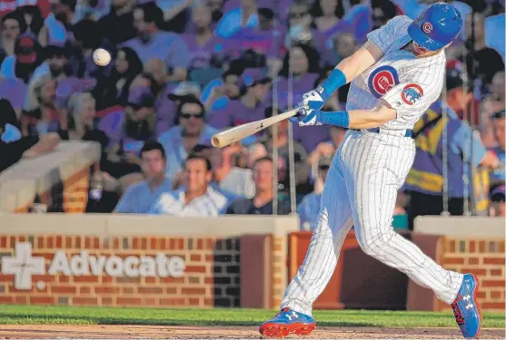  ?? | JON DURR/ GETTY IMAGES ?? Ian Happ connects on the first of his two home runs Sunday against the Cardinals. He hit a solo shot in the third and a three- run blast in the fourth.