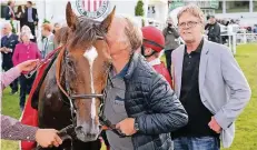  ?? FOTO: KLAUS-JÖRG TUCHEL ?? Siegerkuss für Matchwinne­r von Besitzer Jens Schwarma. Axel Kleinkorre­s (r.) sieht das skeptisch. Im Hintergrun­d Jockey Stephen Hellyn.