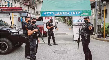  ?? EPA PIC ?? Police officers deployed at a village under lockdown in Manila, Philippine­s, yesterday.