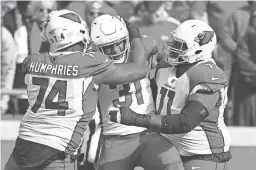  ??  ?? Cardinals running back David Johnson (31) celebrates a touchdown with offensive tackles D.J. Humphries (74) and Andre Smith Sunday.