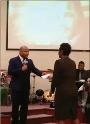  ?? EVAN BRANDT — MEDIANEWS GROUP ?? The Rev. Garrison Lockley, pastor of Bethel AME Church, presents Robin Debnam with part of the proceeds of the night’s offering to help with her husband’s medical care.