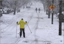  ?? STEVEN SENNE — THE ASSOCIATED PRESS ?? Nelson Taylor, of Providence, R.I., uses cross-country skis while making his way along a residentia­l street on Tuesday in Providence.