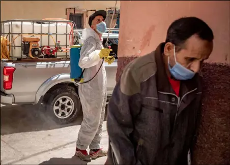  ??  ?? عامل مغربي يعقم مبنى أحد الشوارع في الرباط