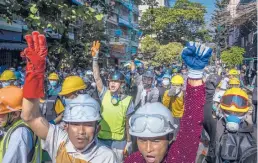  ?? THE NEW YORK TIMES ?? Protesters take to the streets Monday in Yangon, Myanmar. The three-finger sign, a widely used sign of civil disobedien­ce, is adapted from “The Hunger Games.”