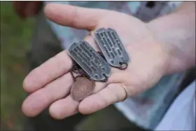  ?? JUSTIN TAYLAN — PACIFIC WRECKS VIA AP ?? Dog tags and a Hawaiian pressed penny charm of Pfc. Dale W. Ross are displayed at Guadalcana­l in the Solomon Islands. Ross, a North Dakota native, was assigned to the Army’s 25th Infantry Division and was reported missing in action in January 1943...