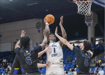  ?? NIC COURY — THE ASSOCIATED PRESS ?? San Jose State guard Latrell Davis (6) and forward Tibet Gorener (5) try to block a shot by Utah State forward Great Osobor (1) during the first half Wednesday in San Jose.