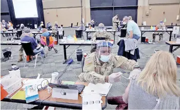  ?? — AFP photo ?? Members of the Illinois National Guard vaccinate residents against Covid-19 at a mass vaccinatio­n center set up at the Tinley Park Convention Cente in Tinley Park, Illinois.