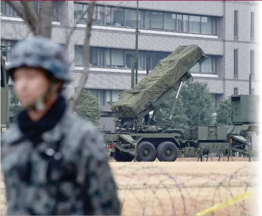  ??  ?? A Japan Self- Defense Forces soldier stands guard near a PAC- 3 surface- to- air missile launcher unit ( center), used to engage incoming ballistic missile threats, in position at the Defense Ministry in Tokyo on Monday. Three of the four missiles...