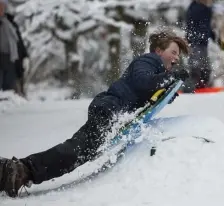  ?? GETTY IMAGES PHOTOS ?? PLENTY OF SNOW: A boy lifts off of a jump while sledding on a hill Saturday in Seattle after a storm blanketed the city with snow.