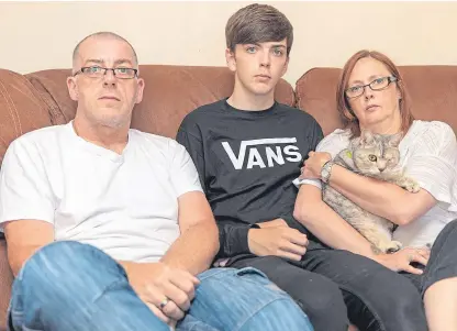  ?? Picture: Steven Brown. ?? From left: Andrew, Scott and Michelle Bartle with their cat, Kameere, who suffered a fractured skull and serious eye injury.
