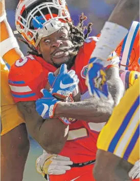  ??  ?? Florida running back Jordan Scarlett shows his intensity as he clings to the ball during the game Saturday against LSU in Baton Rouge, La.| GERALD HERBERT/ AP