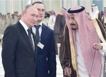  ?? — AFP ?? Saudi King Salman bin Abdulaziz welcomes Russian President Vladimir Putin in Riyadh.