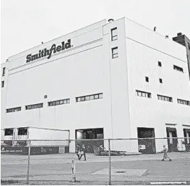  ?? STEPHEN GROVES/AP ?? Employees of two department­s at the Smithfield pork processing plant in Sioux Falls, S.D. report to work on Monday as the plant moved to reopen.