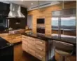  ??  ?? Wood and stainless steel combine to create a sleek and modern kitchen.