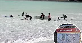  ??  ?? Young surfers were back in the water yesterday despite the signs on Friday warning about sharks.