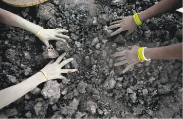  ?? Anupam Nath / Associated Press 2015 ?? Women in Gauhati, India, search for usable pieces of coal from heaps discarded by a factory in 2015.