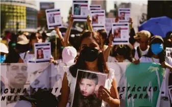  ?? Eduardo Verdugo / Associated Press ?? Protesters carry images of people who have disappeare­d during an annual march in Mexico City on May 10 by families of missing people to demand the government help locate them.