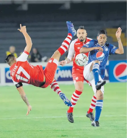  ?? HÉCTOR FABIO ZAMORA /ADN ?? Juan Roa (i) trata de buscar el balón con una maniobra acrobática. A su lado, Christian Marrugo salta para ganar la posesión.