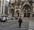  ?? AP ?? GRIM SCENE: New York Police officers block off the scene of a shooting at the Cathedral of Saint John the Divine.