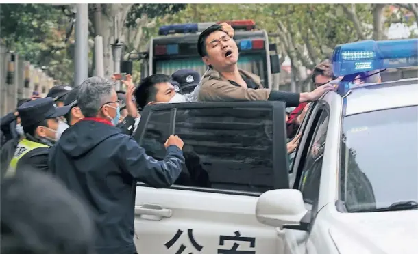  ?? FOTO: AP ?? Ein junger Demonstran­t wird in Shanghai von der Polizei in Gewahrsam genommen.