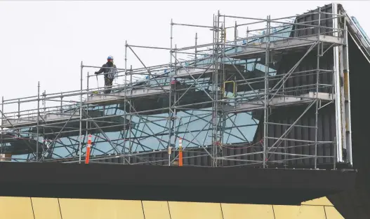  ?? DAVID BLOOM FILES ?? Crews work on the new roof at the EPS'S northwest campus back in October. The city attributes much of the project's cost overruns to defects in the structure's original roof.