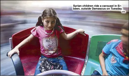  ?? EPA ?? Syrian children ride a carousel in Erbeen, outside Damascus on Tuesday.