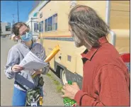  ?? (AP/Manuel Valdes) ?? Moira Andrews, a street outreach nurse for Neighborca­re Health, speaks with Shane Pisson, 48, who lives in an encampment in the Georgetown neighborho­od of Seattle. Andrews spoke with Pisson about the covid-19 vaccines and answered questions in an effort to vaccinate people experienci­ng homelessne­ss.