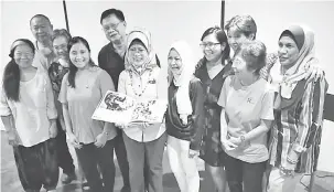  ??  ?? RUJUKAN: Fatimah (tengah) menunjukka­n buku tentang penjagaan paliatif sambil disaksikan kakitangan Two Tree Lodge Hospice Kuching, Pusat Penjagaan Paliatif Hospital Umum Sarawak, Persatuan Kanser Kebangsaan dan Kuching Life Care.