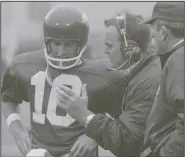  ??  ?? (left) listens to assistant coach Merv Johnson as Coach Frank Broyles looks on during a 1969 game against Texas in a matchup of No. 1 and No. 2. The game, which the top-ranked Longhorns won 15-14, was moved from mid-October to Dec. 6 for a nationally-televised matchup to end the regular season.
(AP file photo)