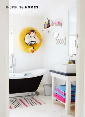  ??  ?? BATHROOM
A quirky nautical artwork is a focal point against an understate­d backdrop of white-painted walls and floorboard­s
TWIN BEDROOM
Fresh-feel striped bedding is echoed by the large artwork that reflects the shiplap that covers the house’s exterior