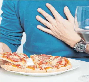  ?? FOTO: SILVIA MARKS/DPA ?? Nach dem Essen kommt der Schmerz: Reichhalti­ge Mahlzeiten und Alkohol gelten als typische Auslöser von Sodbrennen.