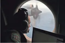  ?? ROB GRIFFITH, AP ?? Flight officer Rayan Gharazeddi­ne scans the southern Indian Ocean off Australia during a search for Flight 370.