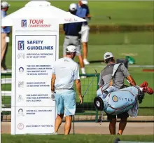  ?? PHOTOS BY CURTIS COMPTON / CURTIS.COMPTON@AJC.COM ?? Brendon Todd walks past the safety guidelines board on his way to the driving range Wednesday.