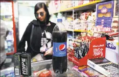  ??  ?? An Iranian customer buys a Pepsi in a grocery store in downtown Tehran on Wednesday.