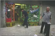  ?? (AP/Suzanne Plunkett) ?? Harry Shasho sweeps up before being evacuated from his vitamin store after the collapse of the World Trade Center on Sept. 11, 2001.