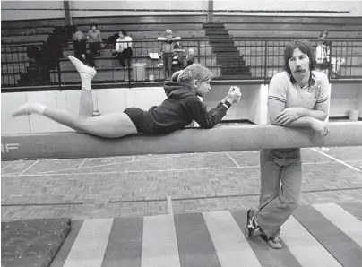  ?? THE COMMERCIAL APPEAL ?? Gymnast Lucy Wener takes a break on the balance beam and relaxes with coach David Neel on March 19, 1981.