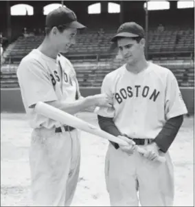  ?? THE ASSOCIATED PRESS ?? Boston Red Sox left fielder Ted Williams, left, tests the arm of Red Sox second baseman Bobby Doerr before a 1942 game against against the White Sox.