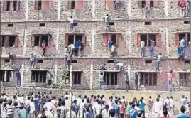  ??  ?? In this 2015 photograph, relatives of students taking exams scale the walls of a building to help pass answers to the candidates in Bihar. Millions of students with a weak learning base make their way into colleges and encounter a higher education...