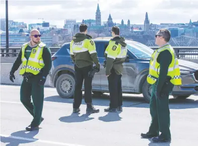  ?? WAYNE CUDDINGTON / POSTMEDIA NEWS ?? Quebec Provincial Police checking for drivers and passengers possibly infected with COVID-19 stop vehicles on the
Macdonald-Cartier Interprovi­ncial Bridge on Wednesday as they entered Gatineau from Ottawa.