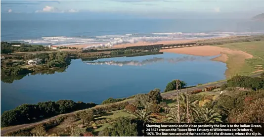  ?? ?? Showing how scenic and in close proximity the line is to the Indian Ocean, 24 3627 crosses the Touws River Estuary at Wilderness on October 6, 1978. The line runs around the headland in the distance, where the slip is.