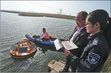  ?? XIE HAO / FOR CHINA DAILY ?? Technician­s check real-time water quality data via a collection device in Qingdao, Shandong province, in 2018.