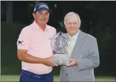  ??  ?? Jack Nicklaus, right, hands Jason Dufner the trophy after winning Sunday’s Memorial golf tournament in Dublin, Ohio.