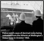  ??  ?? Police watch cases of decimal notes being unloaded from the Athenic at Wellington’s Aotea Quay in October 1966.