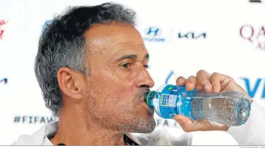  ?? JUANJO MARTÍN / EFE ?? Luis Enrique, selecciona­dor nacional, toma un trago de agua durante la rueda de prensa previa al estreno de España en el Mundial de Qatar.