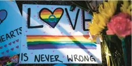  ?? PARKER SEIBOLD/AP ?? The sun shines on a sign placed at a memorial outside Club Q on Monday in Colorado Springs, Colorado. The man suspected of opening fire at the gay nightclub is being held on murder and hate crime charges.