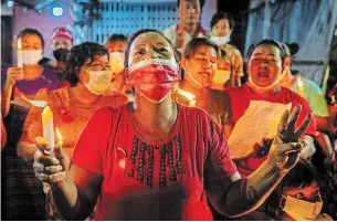  ?? GETTY IMAGES ?? A protester makes a three-finger salute during a candleligh­t protest in Yangon on Friday.