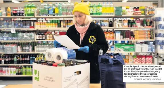  ?? PICTURES: MATTHEW HORWOOD ?? Claudia Apopii checks a food parcel list as staff and volunteers at Cardiff Council help to provide emergency food parcels to those struggling during the coronaviru­s outbreak