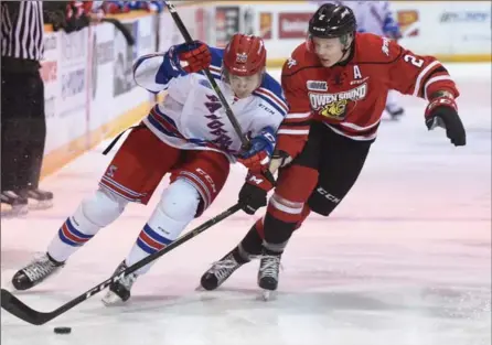  ?? PETER LEE, RECORD STAFF ?? Rangers’ Jonathan Yantsis, left, carries the puck, with Owen Sound’s Jacob Friend in pursuit during action in Owen Sound on Friday night.