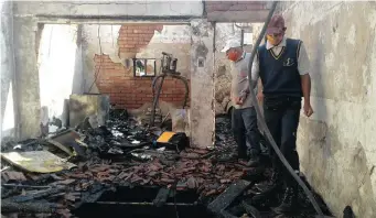  ?? I ZAINUL DAWOOD ?? A BLUFF resident walks through the ruins of a house that burnt down yesterday.